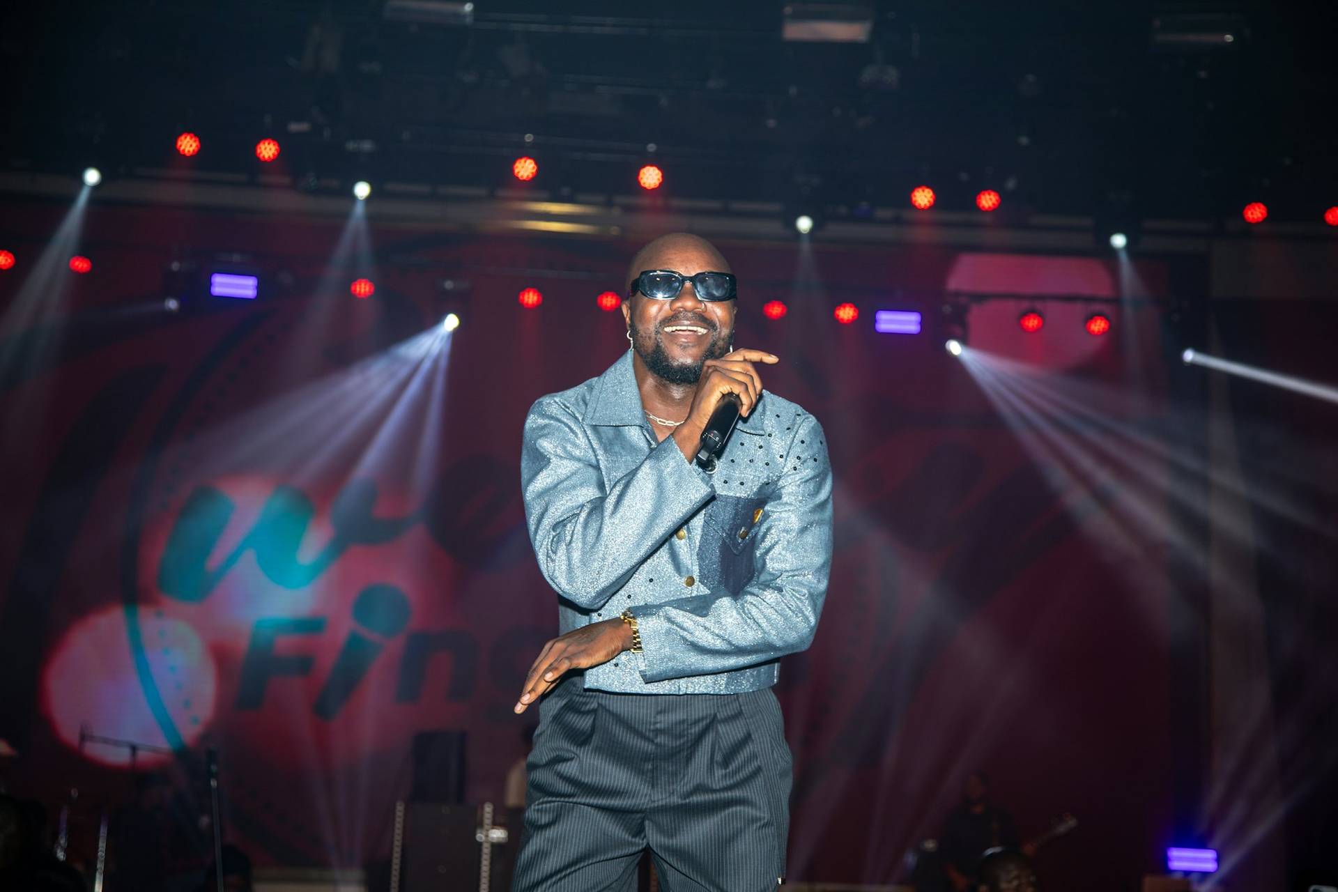 A performer singing on stage under the lights